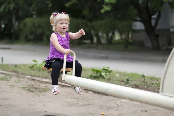 Entzückendes kleines Mädchen, das Spaß auf einem Spielplatz hat — Stockfoto