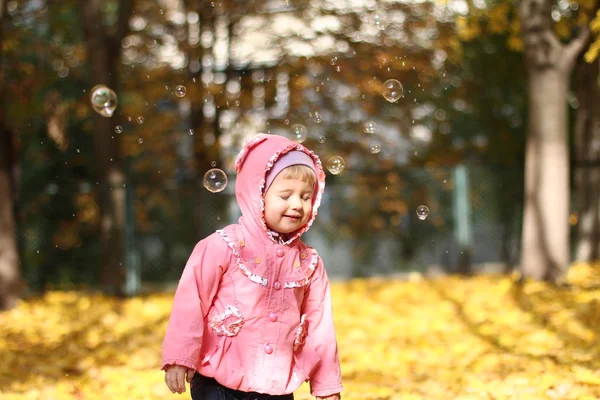 Little girl playing in autumn park — Stock Photo, Image