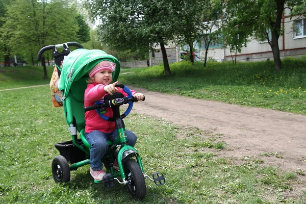 Adorável menina monta uma bicicleta — Fotografia de Stock