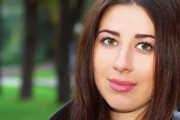 Portrait of brunette girl in the park — Stock Photo, Image