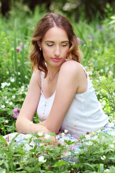 Chica en cama de flores — Foto de Stock