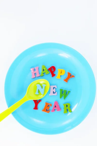 Colorful character Happy New Year greetings in plastic dishes — Stock Photo, Image