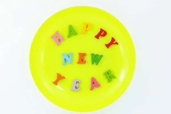 Colorful character Happy New Year greetings in plastic dishes — Stock Photo, Image