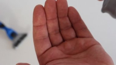 Ellerinizi avuç içinde sıkışmış mavi köpük tıraş jeli.