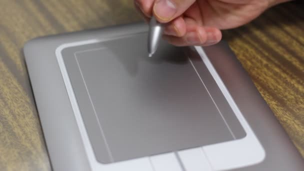L'uomo disegna una penna sul tablet sdraiato sul tavolo da vicino — Video Stock