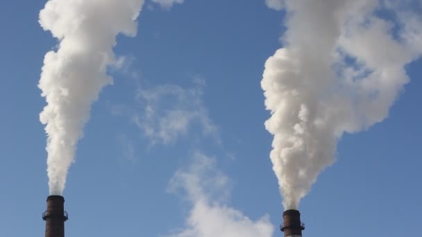 Chimenea de fábrica con humo bajo el cielo azul . — Vídeos de Stock