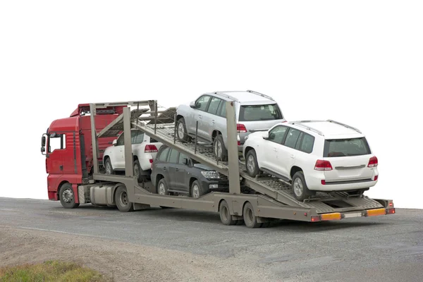 Transportador con coches en la parte posterior, sobre fondo blanco . — Foto de Stock