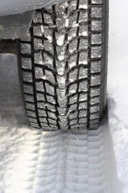 Önümüzde karlı bir kış yolu tanınmaz halde bir araba var.