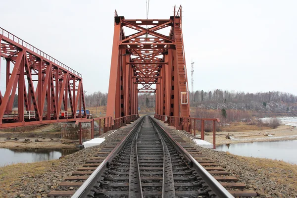 Red metal railway bridge across the river. — Stock Photo, Image