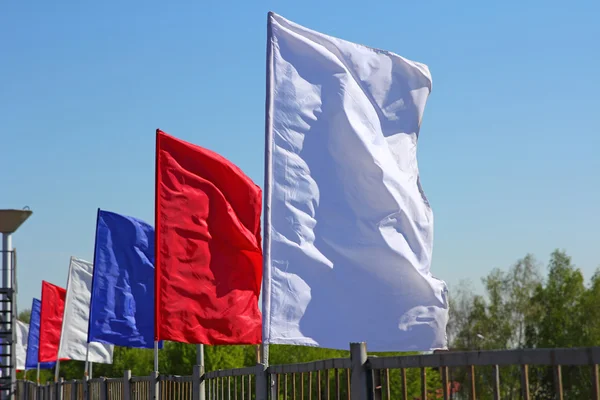 Colored flags on a blue sky background — Stock Photo, Image