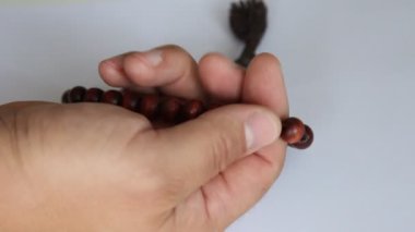 adamın elinde tespih dokunur.