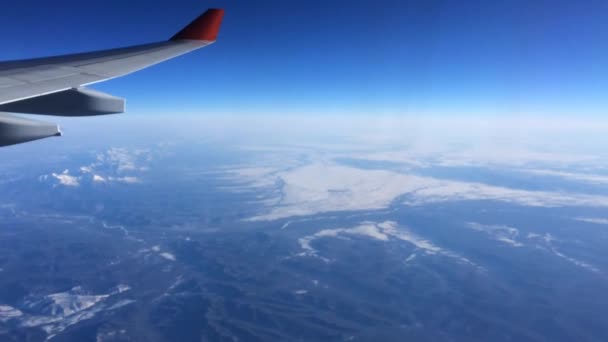 Vol d'avion au-dessus des montagnes dans le ciel bleu . — Video