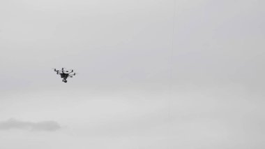 Beyaz bulutların arka plan üzerinde uçan helikopter dron.