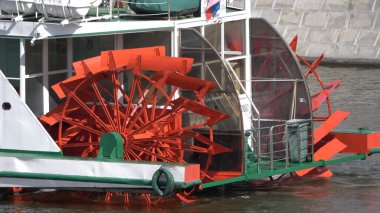 MOSCOW, RUSSIA, 10 Haziran 2021: Red Riverboat Paddle Wheel in a River with Treeson 10 Haziran 2021, Rusya.