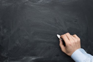 Male hand writing on a blackboard