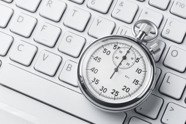 Stopwatch on a laptop keyboard clipart
