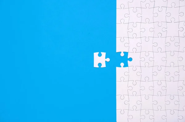 Unfertiges Weißes Puzzle Isoliert Auf Blauem Hintergrund Mit Kopierraum lizenzfreie Stockbilder