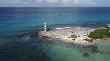 Drone flight over rocks towards lighthouse and caribbean sea