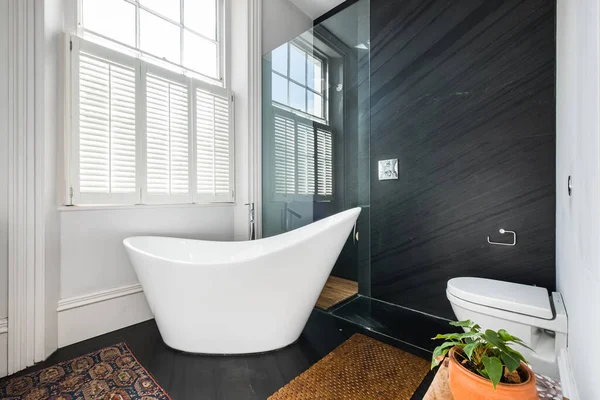 Cosy Designer Bathroom Bath Tub Facing Window Stock Photo