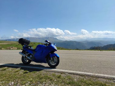 DOMBAY, RUSSIA, 25 Ağustos 2021: Motosiklet konseptiyle seyahat, güzel, huzurlu dağ manzaralı kırsal alanda bisiklet üzerinde görüntüleme