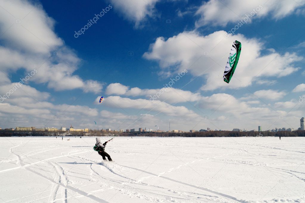 Kite surfer on snowboard on a frozen lake