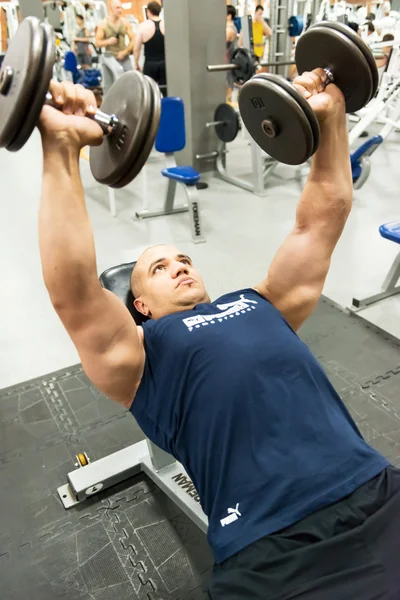 Άνθρωπος που ασχολούνται με την σωματική άσκηση στο γυμναστήριο — Φωτογραφία Αρχείου