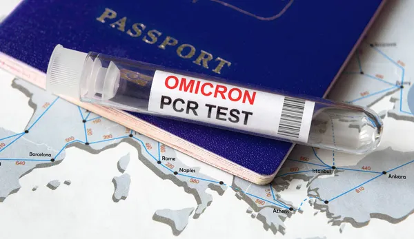 Omicron COVID-19 variant, travel and test concept, tube for corona virus PCR testing and tourist passport on Europe map. Coronavirus diagnostics in airport due to new restrictions and lockdown.