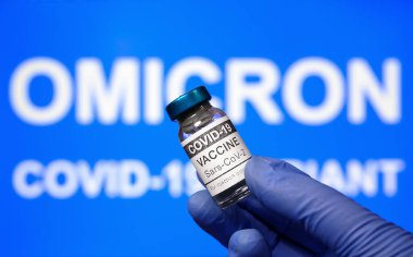 Omicron COVID-19 varyantı ve korona virüs aşısı, aşı şişesine odaklanın. Sağlık kavramı, yeni koronavirüs virüsü, aşı araştırması, yeniden açılması, küresel meydan okuma, teknoloji, dünya krizi ve umut.