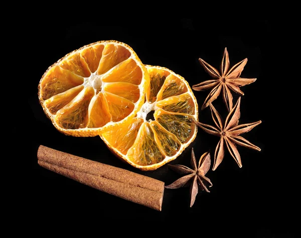 Dried citrus, anis stars and cinnamon on black background — Stock Photo, Image