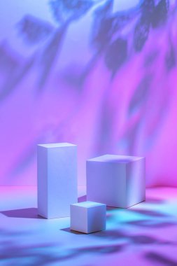 Pastel neon arkaplanda üç dikdörtgen beyaz podyum 