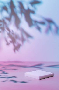 Pastel neon arka planda gölgeli beyaz podyum