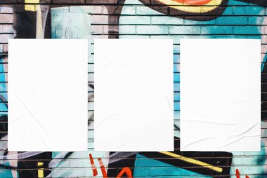 Üç buruşuk yapıştırılmış poster şablonuyla renkli kentsel duvar dokusu