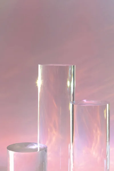 Három átlátszó üveg henger dobogók pasztell rózsaszín háttér — Stock Fotó