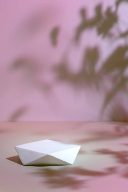 Pembe arka plan ve gölgelerde çokgen podyum sahnesi