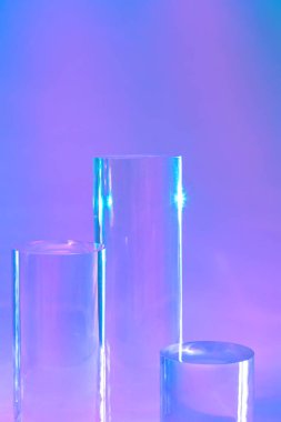 holografik neon arkaplanda üç tane cam silindir podyumu 