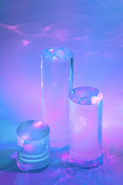 Három átlátszó üvegpalack dobogók holografikus neon háttér — Stock Fotó