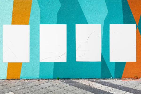 Mur géométrique et quatre modèles d'affiches froissées collées blanches — Photo