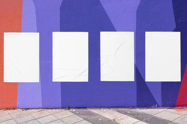 Mur géométrique et quatre modèles d'affiches froissées collées blanches — Photo