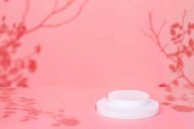 Pembe arka plan ve gölgelerde daire şeklinde podyum sahnesi