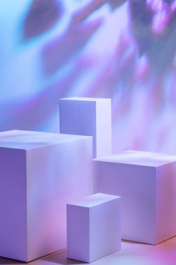 Pastel neon arkaplanda dört dikdörtgen beyaz podyum 