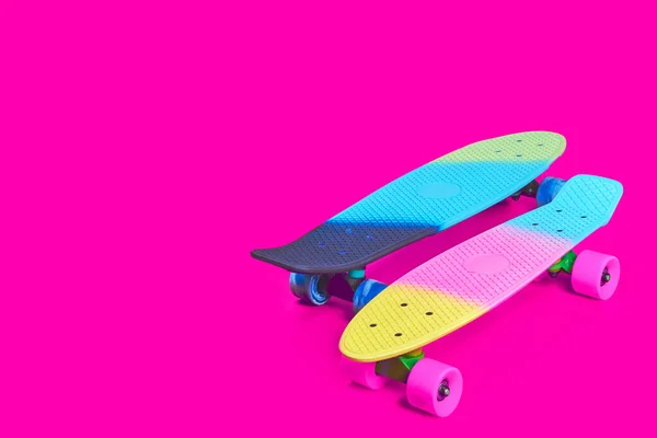 Dois arco-íris plástico Penny prancha skates no fundo carmesim — Fotografia de Stock
