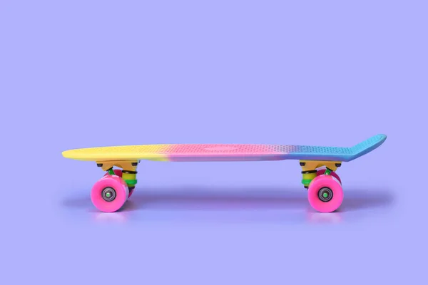 Rainbow plastic Penny board skateboard isolated on purple background — Stockfoto