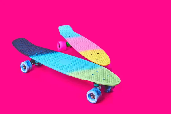 Két szivárvány műanyag Penny board gördeszka bíbor háttér — Stock Fotó