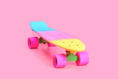 Pembe arka planda izole edilmiş gökkuşağı plastiği Penny kaykayı