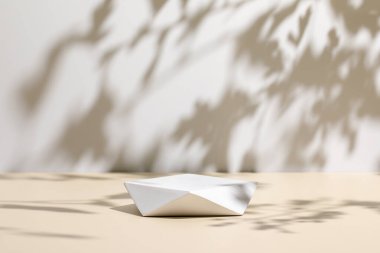 Bej arkaplan ve gölgelerde çokgen podyum sahnesi