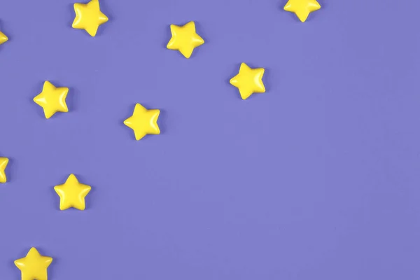 Yellow decorative stars sparse on light purple background — Stock Photo, Image