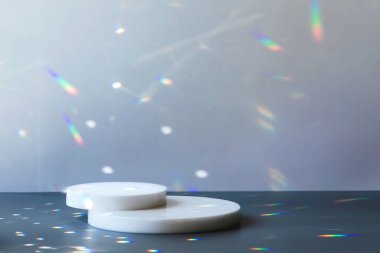 Kristal ışık parıltılarıyla gri zemin üzerinde daire podyumlar
