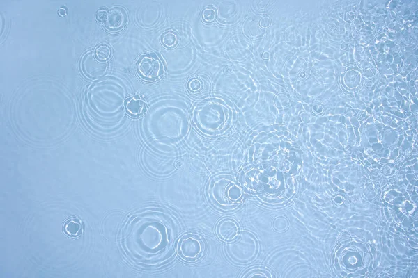Transparente de color azul claro textura de la superficie del agua calma — Foto de Stock