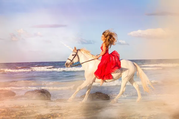 Romantische Frau reitet Einhorn — Stockfoto