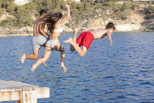 Enfants sautant dans la mer ou l'océan — Photo